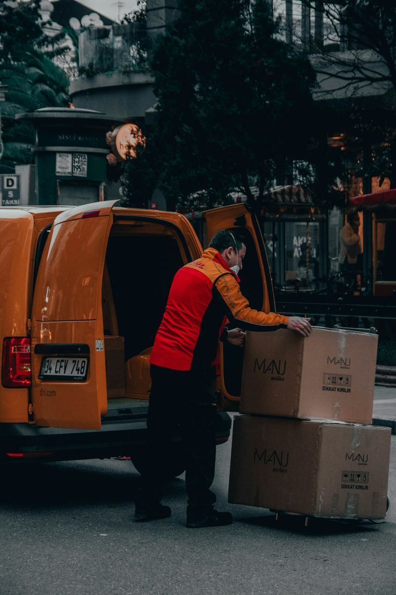 Delivery driver loading boxes into a van